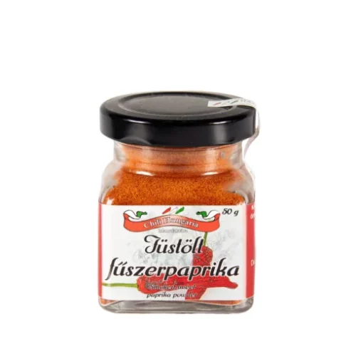 Small glass jar of chili paprika powder with a black lid and red-and-white label (50 g) on a white background